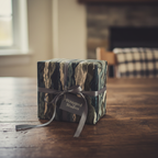 Modern gift box wrapped in blue and green abstract wrapping paper with a gray ribbon.