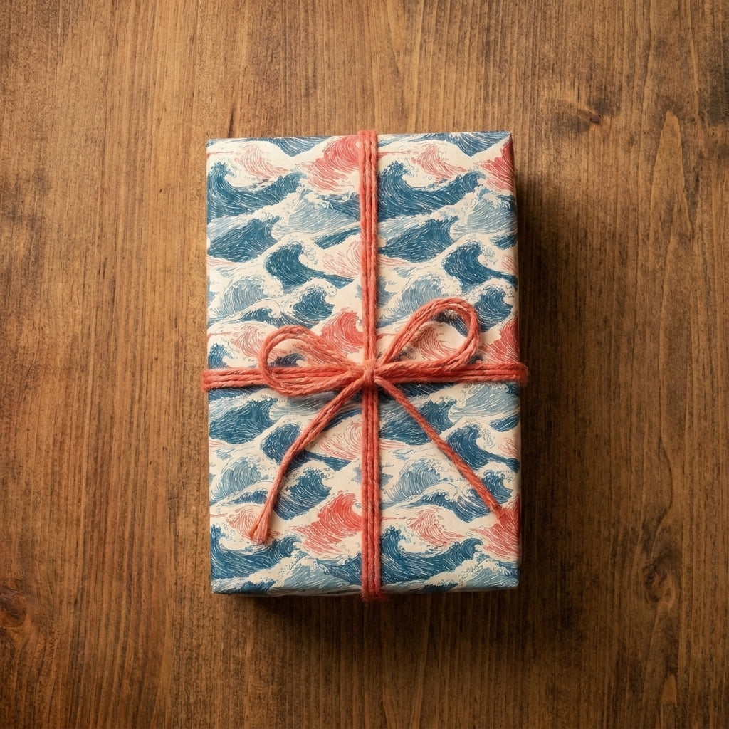 Japanese ocean wave wrapping paper with a coral twine bow on a wood table by Wrapped Studios.