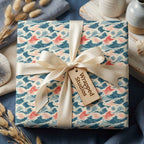 Ocean wave wrapping paper in blue and coral with a cream satin ribbon by Wrapped Studios.