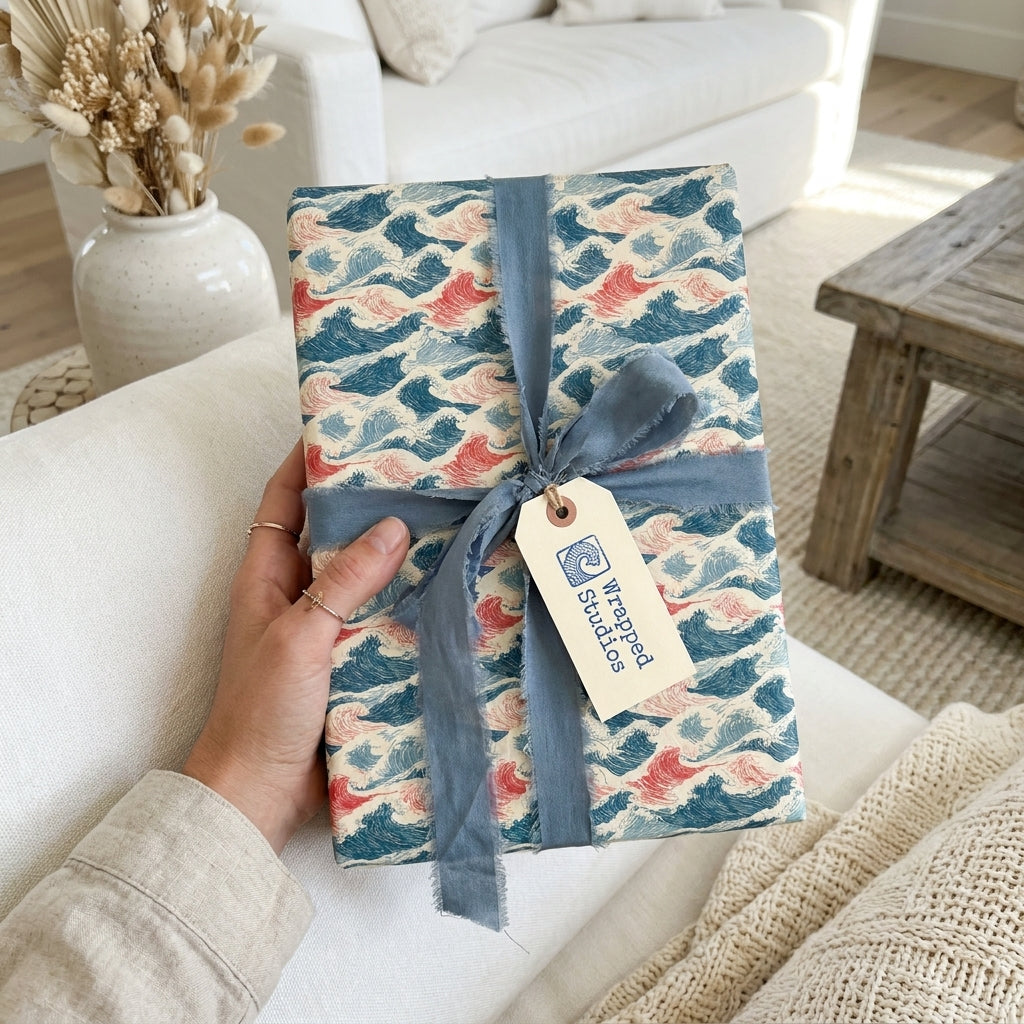 Japanese ocean wave wrapping paper with a dusty blue ribbon and Wrapped Studios tag.
