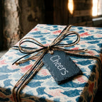 Japanese wave wrapping paper on a gift with a Cheers tag and twine bow by Wrapped Studios.