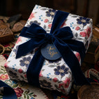 Luxury floral wrapping paper with a navy velvet ribbon and gift tag by Wrapped Studios.