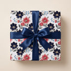 Luxury floral wrapping paper in navy blue and pink with a satin ribbon on a gift box by Wrapped Studios.