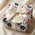 Luxury navy and pink floral wrapping paper with a cream satin bow by Wrapped Studios.