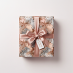 Luxury rose gold and gray abstract gift wrap with glitter accents, tied with a satin ribbon and gift tag, perfect for elegant presents.