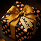 Luxury birthday wrapping paper with orange balloons on black, tied with a gold bow by Wrapped Studios.