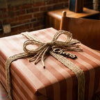 Brown striped wrapping paper with a rustic twine bow and Cheers tag by Wrapped Studios.
