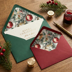 Luxury Christmas cards in green and red envelopes with watercolor ornament liners by Wrapped Studios.