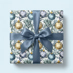 Luxury Christmas wrapping paper with watercolor ornaments and a dusty blue satin bow by Wrapped Studios.