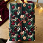 Elegant Christmas gift wrapped in emerald green ornament wrapping paper with rustic twine.