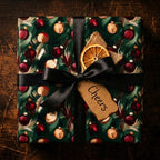 Elegant Christmas gift wrap with red and gold ornaments, a black ribbon, and a "Cheers" tag.