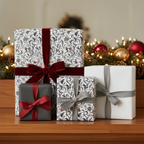 Elegant Christmas gifts with floral wrapping paper and velvet ribbon on a wood surface with holiday decor.