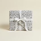 Elegant gift wrapped in floral wrapping paper with white ribbon and "A Small Token" tag.