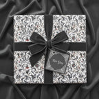 Elegant gift box wrapped in floral wrapping paper with dark velvet ribbon and "For You" tag.
