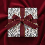 Elegant gift wrapped in vintage floral wrapping paper with a burgundy and gold ribbon.