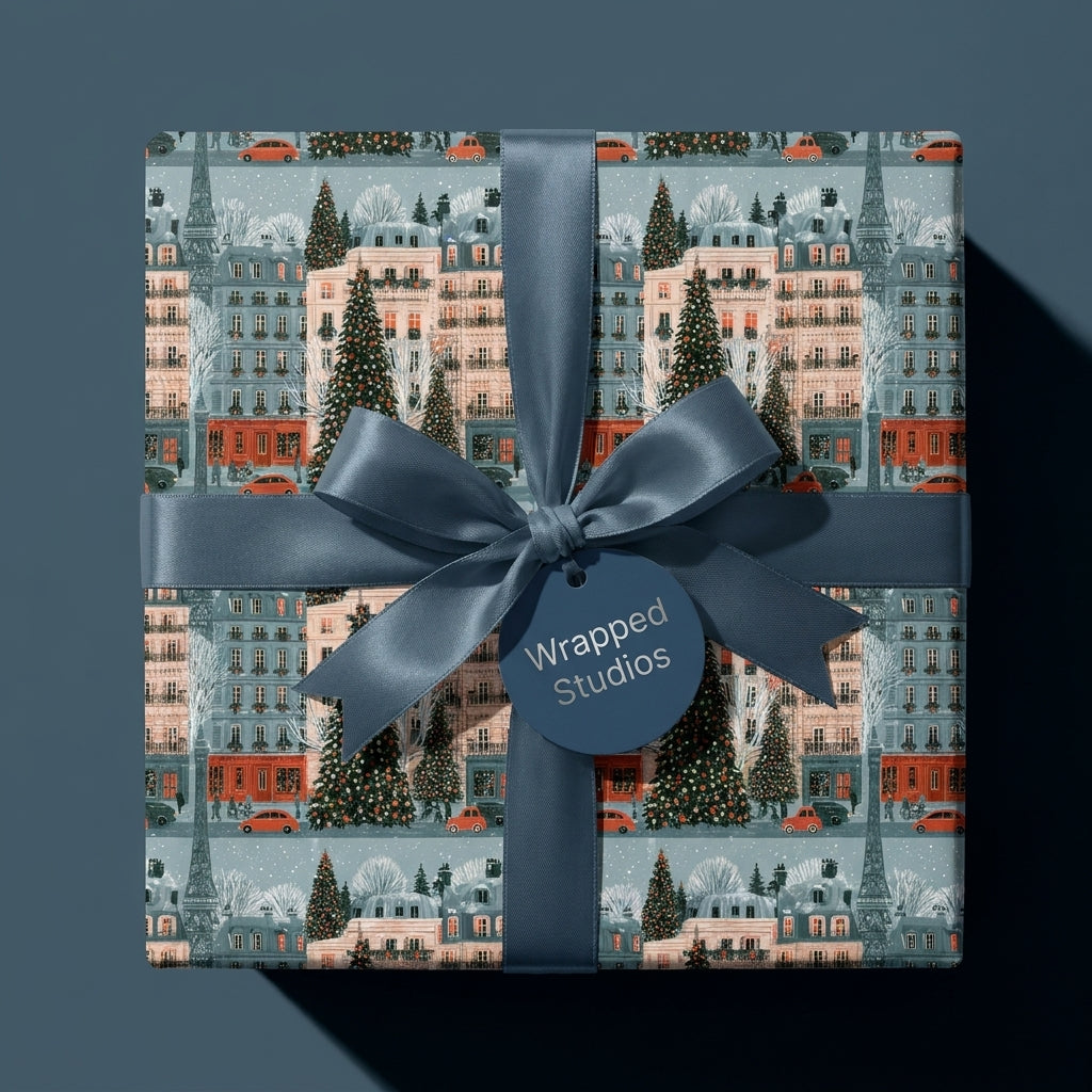 Vintage Paris Christmas wrapping paper with a blue satin ribbon bow on a holiday gift by Wrapped Studios.