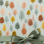 Pastel tree pattern wrapping paper with sage green satin bow, perfect for birthday gift wrap.