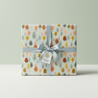 Gift wrapped in modern tree-patterned paper, muted colors with a satin ribbon.