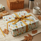 Gift wrapped in autumn tree wrapping paper with gold ribbon, for fall birthdays or thank you gifts.
