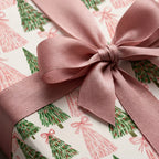 Blush pink and green watercolor Christmas wrapping paper with a satin ribbon bow by Wrapped Studios.