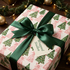 Modern pink and green Christmas tree wrapping paper with a dark green satin bow by Wrapped Studios.