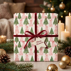 Pink and green watercolor Christmas tree wrapping paper with a red velvet bow by Wrapped Studios.