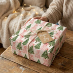 Pink and green Christmas tree wrapping paper on a cozy holiday gift, by Wrapped Studios.