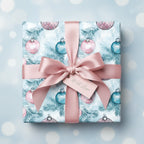 Square gift box with festive Christmas ornament wrapping paper and blush ribbon.