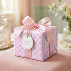 Elegant pastel cross wrapping paper with a large pink satin bow on a gift box, from Wrapped Studios.