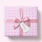 Pastel pink and blue cross wrapping paper with a satin ribbon for baby showers or baptisms by Wrapped Studios.