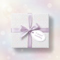 Pastel polka dot wrapping paper with lilac ribbon and "A special something" tag.