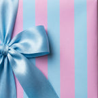 Pink and blue striped wrapping paper with a satin bow, ideal for baby showers and birthdays by Wrapped Studios.