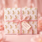 Cute pink monkey wrapping paper with a satin ribbon and Wrapped Studios gift tag, ideal for baby shower gifts.