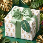 Safari monkey wrapping paper by Wrapped Studios on a birthday gift with a sage green bow and tropical leaves.