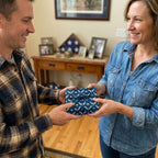 Navy blue Air Force wrapping paper with stars on a gift being exchanged, by Wrapped Studios.