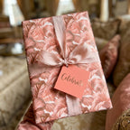 Luxury pink floral wrapping paper with a dusty rose ribbon and Celebrate tag by Wrapped Studios.