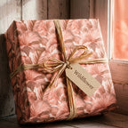 Vintage wildflower floral wrapping paper in dusty pink with a raffia ribbon by Wrapped Studios.