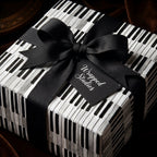 Piano keys music wrapping paper with a black ribbon by Wrapped Studios.
