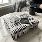 Piano keys music wrapping paper with a silver bow on a gift by Wrapped Studios.