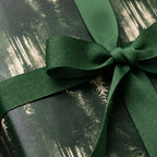 Green forest wrapping paper with a dark green ribbon, luxury Christmas gift wrap by Wrapped Studios.