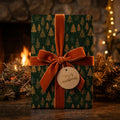 Luxury green Christmas wrapping paper with gold trees and a rust velvet bow by Wrapped Studios.