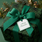 Luxury pine branch Christmas wrapping paper with a green ribbon and tag by Wrapped Studios.