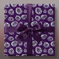 Square gift in purple pinecone Christmas wrapping paper with matching satin ribbon bow.