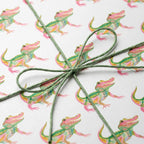 Cute alligator wrapping paper with a green twine bow, playful birthday gift wrap by Wrapped Studios.