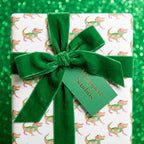 Whimsical alligator birthday wrapping paper with a green velvet bow by Wrapped Studios.