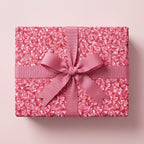 Pink luxury wrapping paper with a matching grosgrain ribbon bow on a gift box by Wrapped Studios.