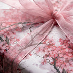 Elegant cherry blossom wrapping paper with a pink sheer ribbon bow, luxury floral gift wrap by Wrapped Studios.
