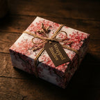 Pink cherry blossom floral wrapping paper by Wrapped Studios on a gift box tied with rustic twine.