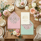 Ditsy floral wrapping paper liners in pink and mint envelopes on a spring brunch table by Wrapped Studios.