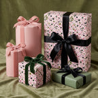 Pink floral wrapping paper and luxury gift wrap with velvet ribbons on green velvet by Wrapped Studios.